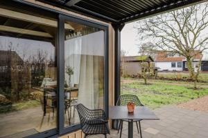 a screened in patio with a table and chairs at Luxe Tiny House op minicamping in Waarde in Waarde