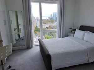 ein Schlafzimmer mit einem großen Bett und einem großen Fenster in der Unterkunft Cozy Double Room with Large En Suite Near Canary Wharf London with Amazing Views in a Shared Apartment in London