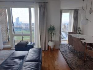 ロンドンにあるCozy Double Room with Large En Suite Near Canary Wharf London with Amazing Views in a Shared Apartmentのリビングルーム(ソファ、テーブル付)、ダイニングルーム +14枚の写真