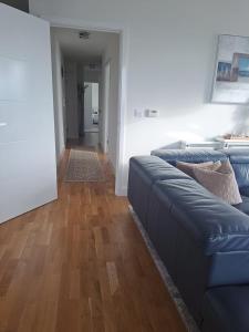 een woonkamer met een blauwe bank en een houten vloer bij Cozy Double Room with Large En Suite Near Canary Wharf London with Amazing Views in a Shared Apartment in Londen