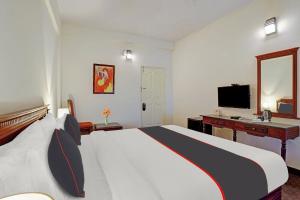 Pokój hotelowy z dużym łóżkiem i telewizorem w obiekcie Collection O Narendra Regency w mieście Punalūr