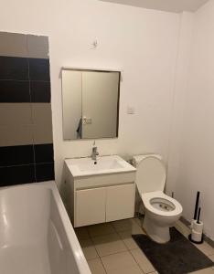 een badkamer met een bad, een toilet en een wastafel bij Belle appartement sur liège in Luik