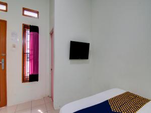 Camera con letto e TV a parete di SPOT ON 92797 Awi Stay Syariah a Dumai