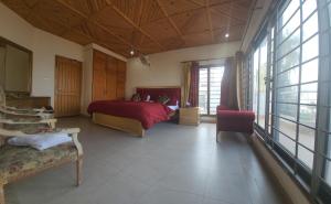 a bedroom with a red bed and some windows at Haven Lodge Bhurban, 6BR Holiday Home in Hill Station in Bhurban