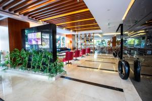 a lobby of a restaurant with red chairs and plants at Ramada Encore Istanbul Kartal in Istanbul