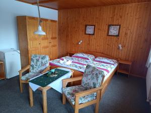 a bedroom with a bed and a table and chairs at Privát Majo in Liptovský Mikuláš