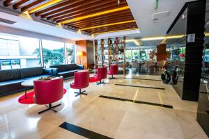 a lobby of a hotel with red chairs and tables at Ramada Encore Istanbul Kartal in Istanbul