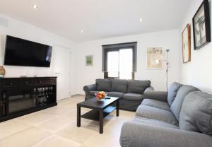 ein Wohnzimmer mit Couch und Flachbildfernseher in der Unterkunft Charming Mallorca Apartment 3 Bedrooms Villa Townhouse Alnair in Port de Pollença + 4 Fotos