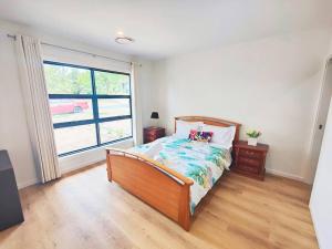 sypialnia z łóżkiem i dużym oknem w obiekcie Brand new settled house near shops with Netflix w mieście Weetangerra