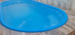 uma banheira azul cheia de água num piso de madeira em Casa Areal, 1 Suíte, 2 quartos, piscina garagem para 2 carros em Pelotas