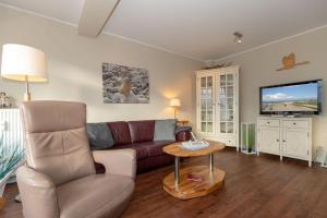 a living room with a couch and a tv at Urlaubstraeume-am-Meer-Wohnung-6-8-9808 in Kühlungsborn