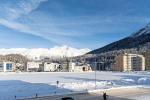 a snow covered city with mountains in the background at Idyllic apartment in St. Moritz in St. Moritz