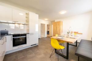 cocina con mesa de madera y sillas amarillas en Idyllic apartment in St. Moritz, en St. Moritz