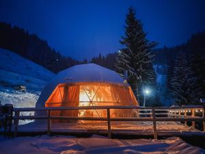 a igloo is lit up in the snow at night at Cucu Zen Dome Cabana Cazare Bucovina 