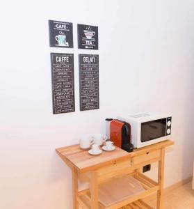un tavolo con forno a microonde e tazze sopra di CasaLina Appartamento a Santa Croce sullʼ Arno