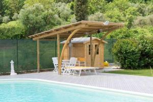 a wooden pergola next to a swimming pool at CasaLina Appartamento in Santa Croce sullʼ Arno