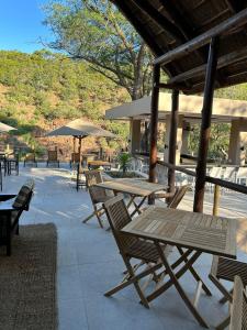 an outdoor patio with tables and chairs and umbrellas at Mologa River Lodge in Rust de Winter