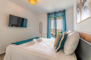 Schlafzimmer mit einem weißen Bett und einem Fenster in der Unterkunft Dieu Nérée & sa vue mer in Sète