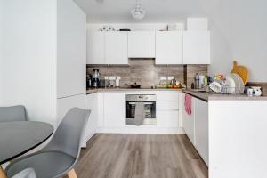 a kitchen with white cabinets and a table and chairs at Charming room in the Heart of London in London