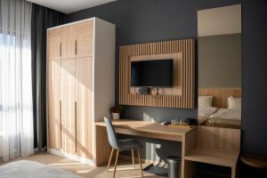 a bedroom with a desk and a tv on a wall at Olivia Rooms in Belgrade