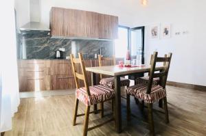 Apartment Alegria in Mozaga في Mozaga: مطبخ مع طاولة وكراسي خشبية