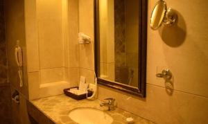 a bathroom with a sink and a shower with a mirror at FabHotel Prime Centurion in Pune