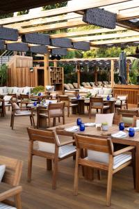 a restaurant with wooden tables and chairs on a deck at No81 Hotel in Golturkbuku