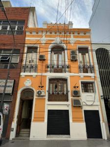 Edificio naranja y blanco con ventanas y balcones en Derby Home Hotel en Buenos Aires