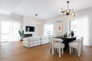 a white living room with a table and white chairs at Phaedrus Living: Glyfada Seaview Luxury Penthouse in Athens