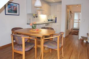 a kitchen and dining room with a wooden table and chairs at Apartmentvermittlung Mehr als Meer - Objekt 52 in Niendorf