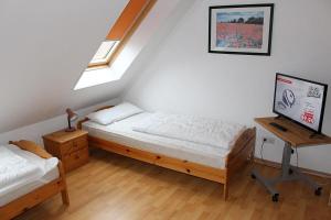 a bedroom with two beds and a desk with a tv at Apartmentvermittlung Mehr als Meer - Objekt 52 in Niendorf