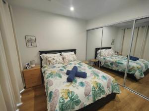 a bedroom with two beds and a mirror at Brand new settled beautiful house，near shops in Weetangerra