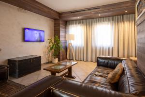 a living room with a leather couch and a table at Hotel Don Luis in Castel di Sangro