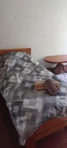 a bed with a comforter on top of it at Apartment V&D in Berovo