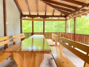 une table en bois et des bancs dans une cabine dans l'établissement Apartment V&D, à Berovo