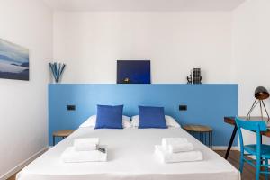 a bedroom with a bed with blue walls and blue chairs at Casa Peppino Verona in Verona