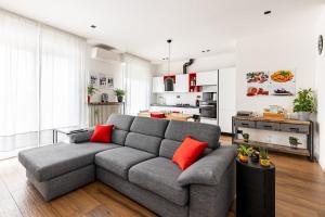 a living room with a gray couch with red pillows at Casa Peppino Verona in Verona