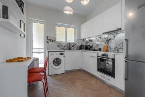 雅典的住宿－Phaedrus Living: Glyfada Seaview Luxury Penthouse，厨房配有白色橱柜、洗衣机和烘干机