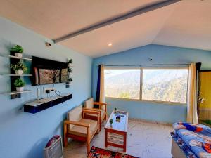 een woonkamer met uitzicht op een berg bij The Pahadi Nest Mukteshwar in Mukteswar