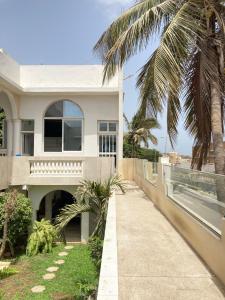 a house on the beach with a palm tree at Studio cosy sur la corniche in Dakar