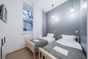 Halės Guest House - Lollo Luxury في فيلنيوس: سريرين في غرفة صغيرة مع نافذة