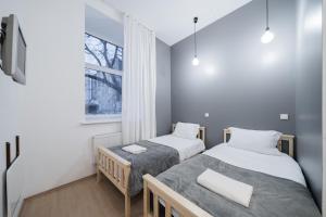 two beds in a small room with a window at Halės Self Check-in Guest House - Lollo Stay in Vilnius