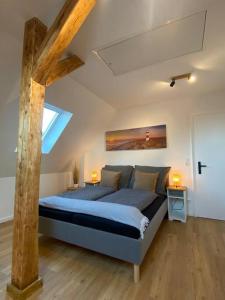 1 dormitorio con 1 cama grande y 2 lámparas. en Modernes City Apartment nahe Hbf, en Emden