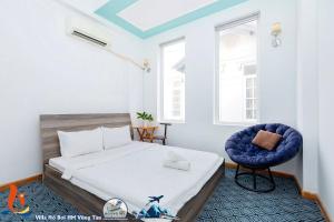 een slaapkamer met een bed en een blauwe stoel bij Biệt Thự ĐĂNG KHOA Hồ Bơi Bida karaoke in Vung Tau