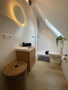 La salle de bains est pourvue d'un lavabo et de toilettes. dans l'établissement Modernes City Apartment nahe Hbf, à Emden