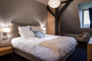 1 dormitorio con 1 cama blanca grande y 1 silla en LES GITES DE LA KARLSMUHLE en Haguenau