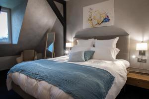 sypialnia z dużym łóżkiem z białymi poduszkami w obiekcie LES GITES DE LA KARLSMUHLE w mieście Haguenau