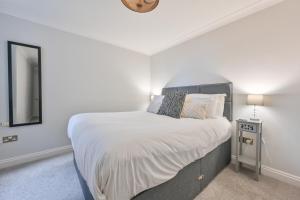 een slaapkamer met een groot bed en een spiegel bij Top Floor Sandbanks Apartment with Free Parking just minutes from the Beach and Bars in Canford Cliffs