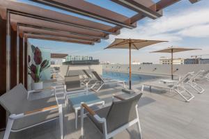 a rendering of a patio with chairs and tables and umbrellas at Spacious 3BR Apartment Near Miracle Garden in Dubai