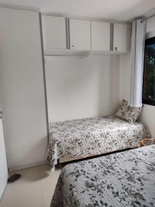 1 dormitorio con 2 camas y ventana en Flat Cantinho do Paraíso, en Guarajuba